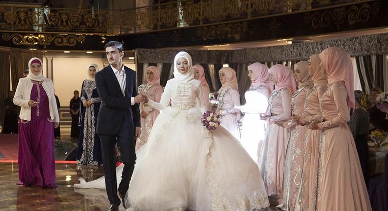 Chechen newlyweds, Zara Khasanova and her groom, prepare to dance during a wedding ceremony in Grozny. Chechen weddings are traditionally paid for by the groom and attended by his family members