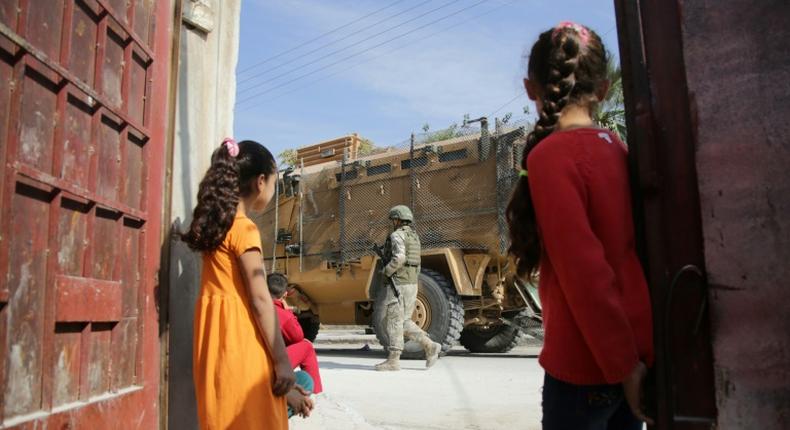 Turkish soldiers patrol the northern Syrian Kurdish town of Tal Abyad near the Turkish border on Wednesday