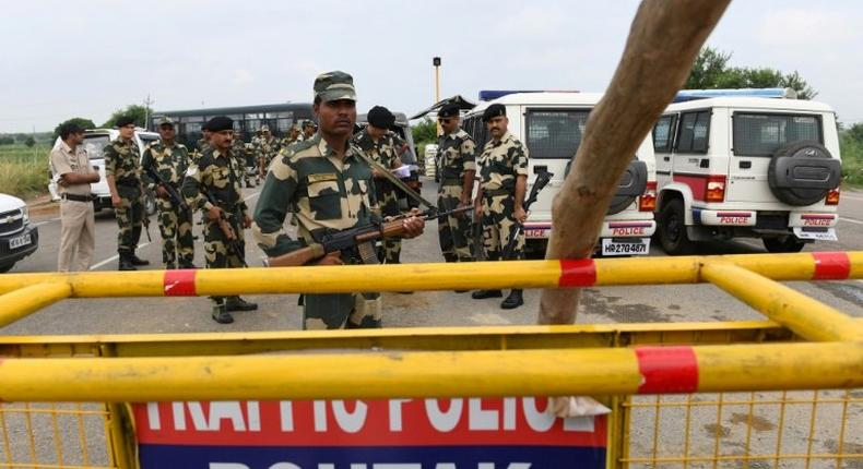 Indian security personnel stand guard along a road near Sonariya jail in Rohtak