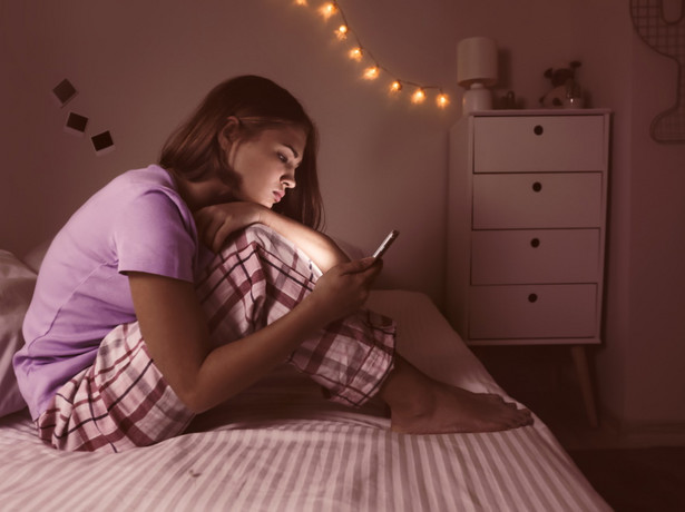 Nastolatka używa telefonu w nocy