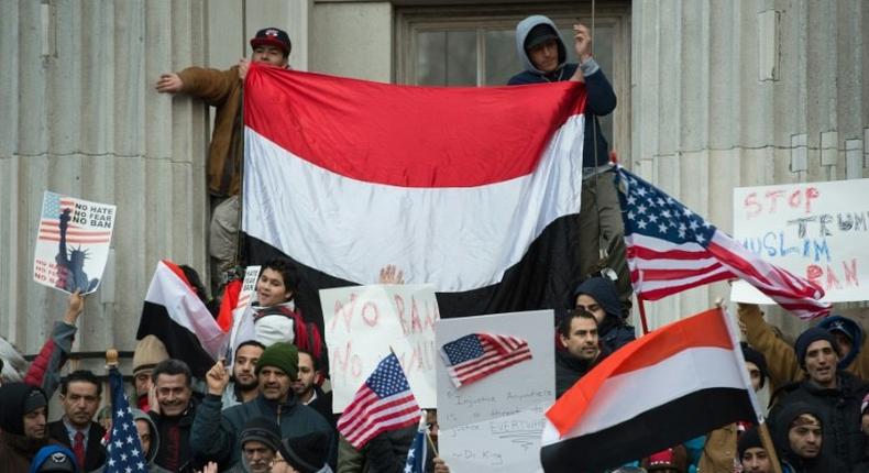 People rally with flags at Brooklyn Borough Hall as Yemeni bodega and grocery-stores shut down to protest US President Donald Trump's Executive Order banning immigrants and refugees from seven Muslim-majority countries on February 2, 2017 in New York