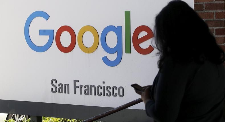 FILE - In this May 1, 2019, file photo, a person walks past a Google sign in San Francisco. Google employees are calling on the company to pledge it wont work with U.S. Customs and Border Protection or Immigration and Customs Enforcement _ the latest in a year full of political and social pushback from the tech giants workforce. (AP Photo/Jeff Chiu, File)