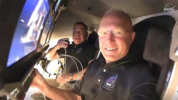 epa08456322 A handout video-grabbed still image made available by NASA on 31 May 2020 shows NASA astronauts Doug Hurley (foreground) and Bob Behnken call down to mission controllers for a report on their second flight day onboard the SpaceX Crew Dragon spacecraft on NASA's SpaceX Demo-2 mission approaching to dock to the International Space Station (ISS), 31 May 2020. NASA's SpaceX Demo-2 mission to the International Space Station with NASA astronauts Robert Behnken and Douglas Hurley on-board was launched from NASA's Kennedy Space Center in Cape Canaveral, Florida, USA, 30 May 2020. EPA/NASA TV HANDOUT MANDATORY CREDIT: NASA TV HANDOUT EDITORIAL USE ONLY Dostawca: PAP/EPA.