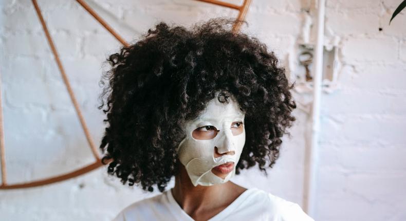 Black woman with facial mask on bed [Photo: Sora Shimazaki]