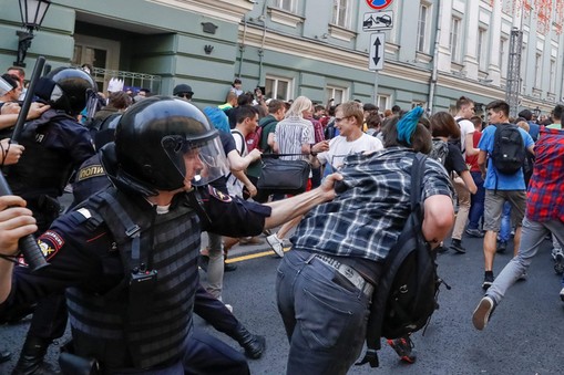 Police officers chase protesters during a rally against planned increases to the nationwide pension 