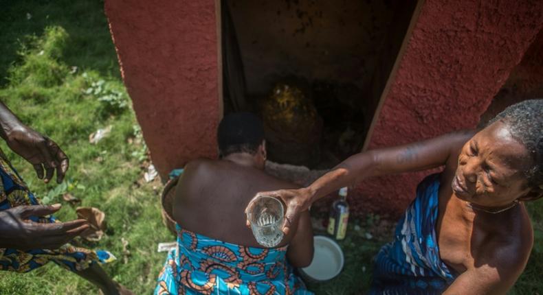 Sacred: Priestesses in Porto-Novo give offerings to a voodoo idol