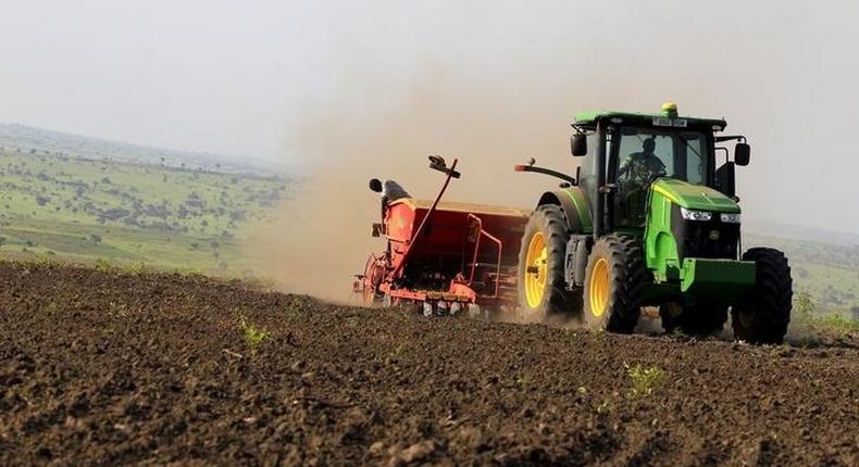 A man stands on a planter towed by a tracter during seeds planting in a field at Amatheon Agri farm in Nwoya district in northern Uganda, July 16, 2015. Picture taken July 16, 2015. REUTERS/James Akena