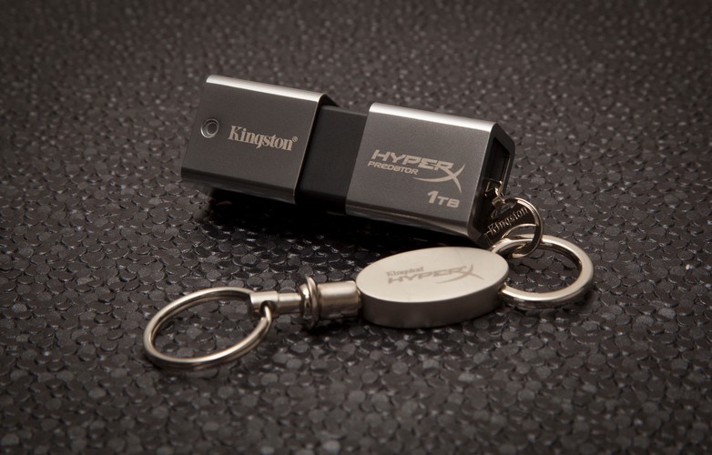 Nowy pendrive DataTraveler HyperX Predator 3.0 Kingstona jest doskonałym rozwiązaniem dla wszystkich, którzy oczekują najwyższych prędkości transferu danych oraz możliwości edytowania dużych plików takich jak filmy w jakości HD bezpośrednio z nośnika. Pojemność 1 TB sprawia, że możemy ze sobą nosić sporą bibliotekę filmów i muzyki. Treści z pamięci na komputer można przesyłać z prędkością 260 Mb/s. Na urządzeniu pliki zapisują się nieco wolniej po 160 Mb/s. Pendrive jest odporny na wstrząsy i można do niego przymocować smycz, którą otrzymamy w komplecie z urządzeniem. Za tak duży przenośny magazyn danych trzeba słono zapłacić. Urządzenie kosztuje aż 4500 zł. Na zdj. Pendrive DataTraveler HyperX Predator 3.0 Kingston. Źródło: www.kingston.com