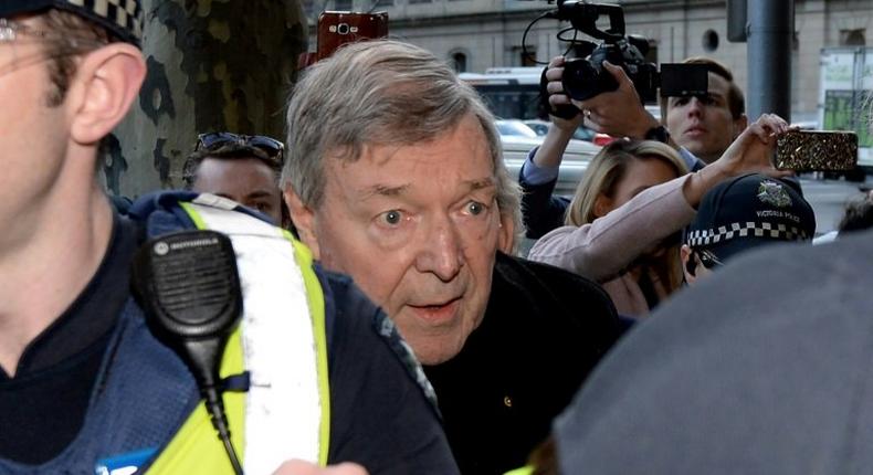 Cardinal George Pell arrives under heavy police protection for his first court hearing over historical sexual abuse allegations