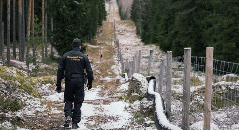 A border guard walks along a fence marking the boundary between Finland and Russia near Imatra, Finland in November 2022.ALESSANDRO RAMPAZZO/AFP via Getty Images