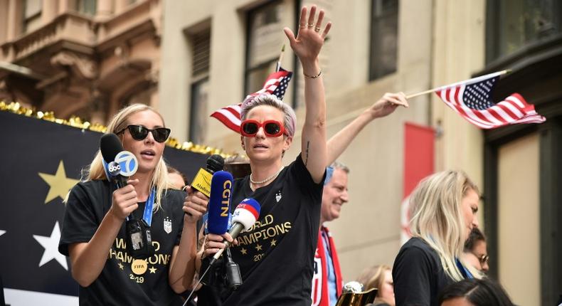 World Cup star Megan Rapinoe waves a US flag as the US women's World Cup-winning soccer team is feted with a ticker tape parade in New York