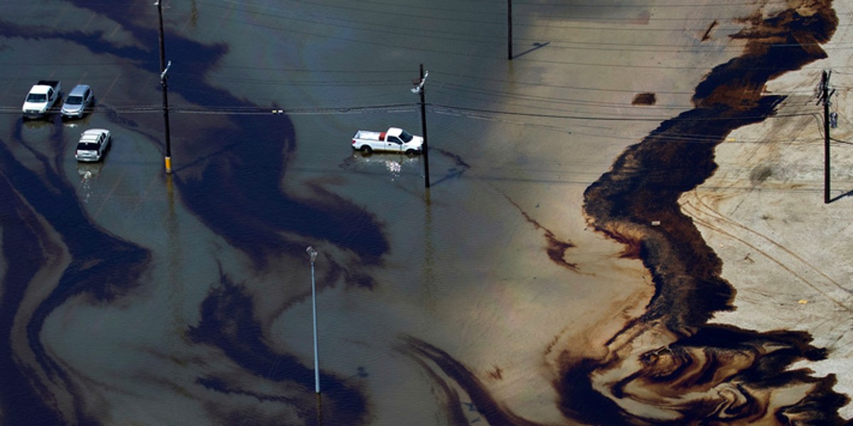 Cars sit in a pool of leaked fuel and floodwaters after Harvey smacked Port Arthur, Texas.