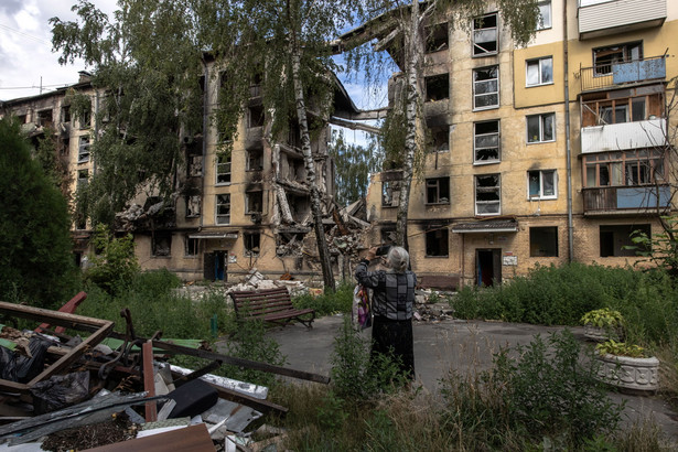 epa10081397 Olena Barva outside the residential building where she lived, destroyed during Russian attacks, as she visits the area for the first time since she fled when the Russian invasion began in February, in Hostomel, northwest of the capital city of Kyiv, Ukraine, 19 July 2022. Olena left her apartment late on 24th February when Russia began its invasion of Ukraine, and Hostomel became one of the first targets of Russian troops. She then moved to Bucha and from there later fled to the western part of Ukraine, where she lives now. After many months Olena came back from there to Hostomel to see what is left of her apartment in the residential building that was destroyed during the Russian attacks, and where she lived as she said for 44 years. Due to the risk of collapse of the building, she could not go to see her apartment on the 5th floor, the most of which was mainly collapsed. Taking photos of the building with her mobile phone for her memory she said: 'I see there my white cooking stove is still standing'. She does not know what her future will be look like. So far she settled in the west of the country but has hope one day to return to Hostomel. Hostomel, as well as other towns and villages in the northern part of the Kyiv region, became battlefields, heavily shelled, causing death and damage when Russian troops tried to reach the Ukrainian capital of Kyiv in February and March 2022. EPA/ROMAN PILIPEY ATTENTION: This Image is part of a PHOTO SET Dostawca: PAP/EPA.