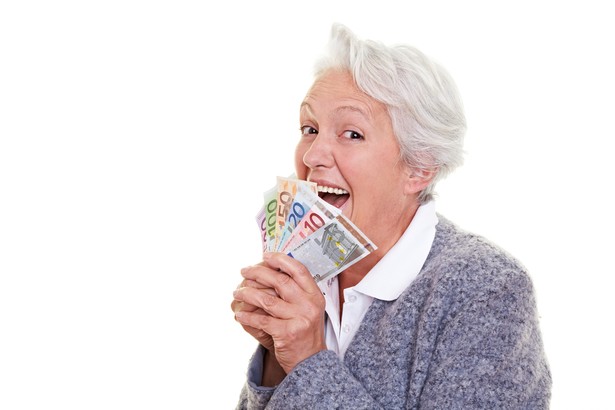 Seniorka z plikiem banknotów w dłoni