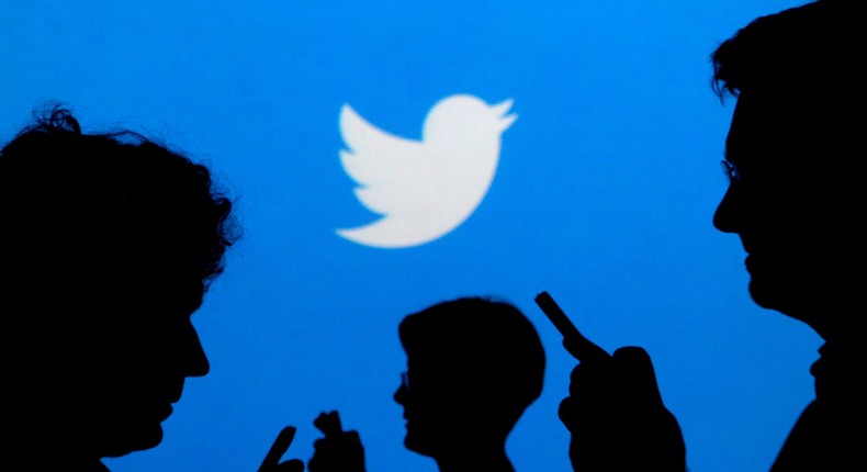 FILE PHOTO: People holding mobile phones are silhouetted against a backdrop projected with the Twitter logo in this illustration picture taken September 27, 2013. REUTERS/Kacper Pempel/Illustration/File Photo