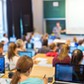 44192156 - rear view of students sitting and listening in lecture hall doing practical tasks on thei