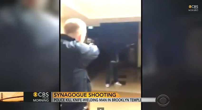 Policijac drži pištolj uperen ka napadaču