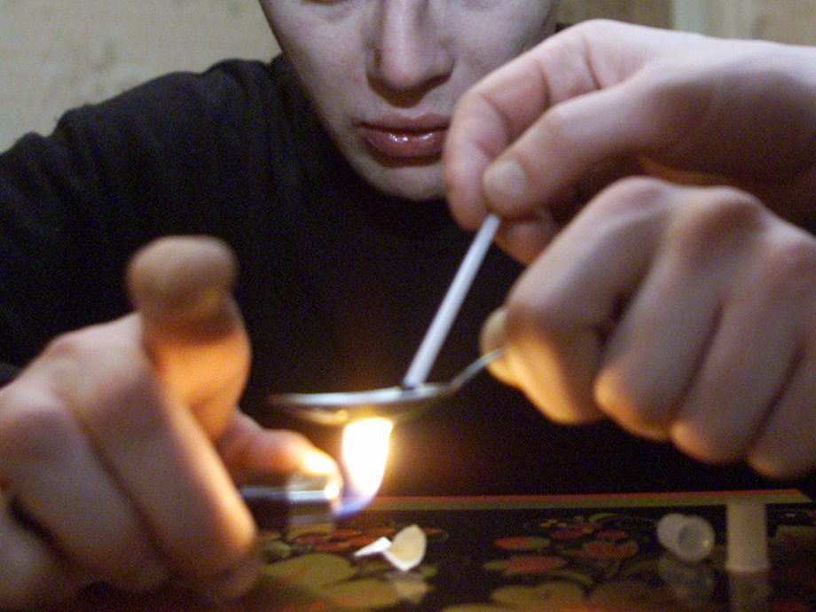 A young man preparing heroin for injection at an apartment in the Moscow satellite town of Zhukovsky in 2000.