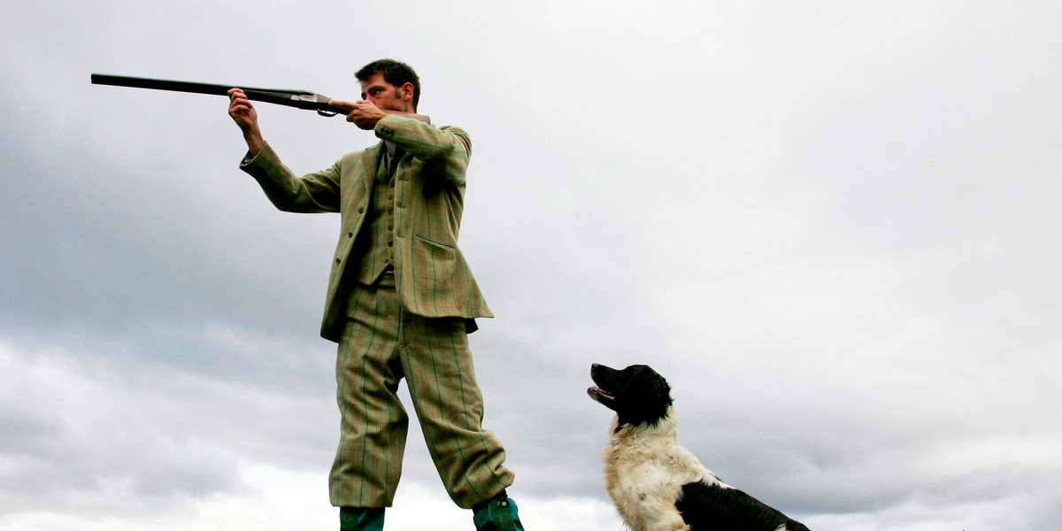 Milton estate's gamekeeper Andrew Drummond stands on Drumochter Moor taking aim with his shotgun, accompanied by his Springer Spaniel, Dan.