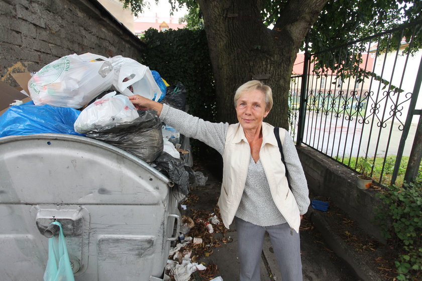 Kobieta wrzuca śmieci do śmietnika