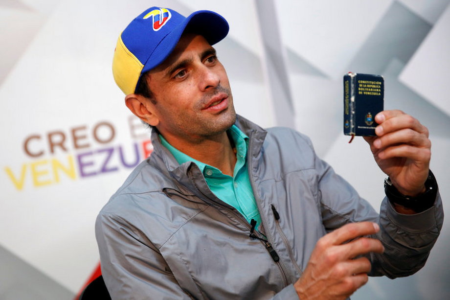 Venezuelan opposition leader Henrique Capriles, with a copy of the Venezuelan constitution, in Caracas, May 26, 2016.