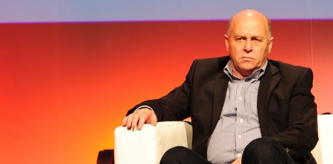 Prezes PZPN Grzegorz Lato na tle nowego logo Związku