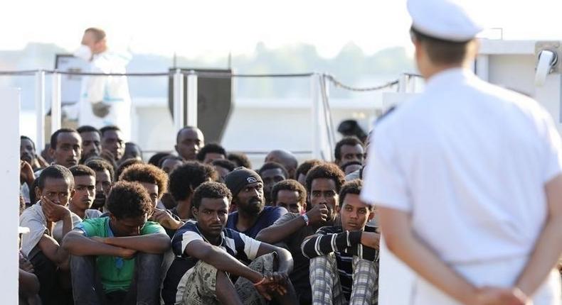 Migrants wait to disembark from a Coast Guard ship in the Sicilian harbour of Messina, Italy August 29, 2015. 