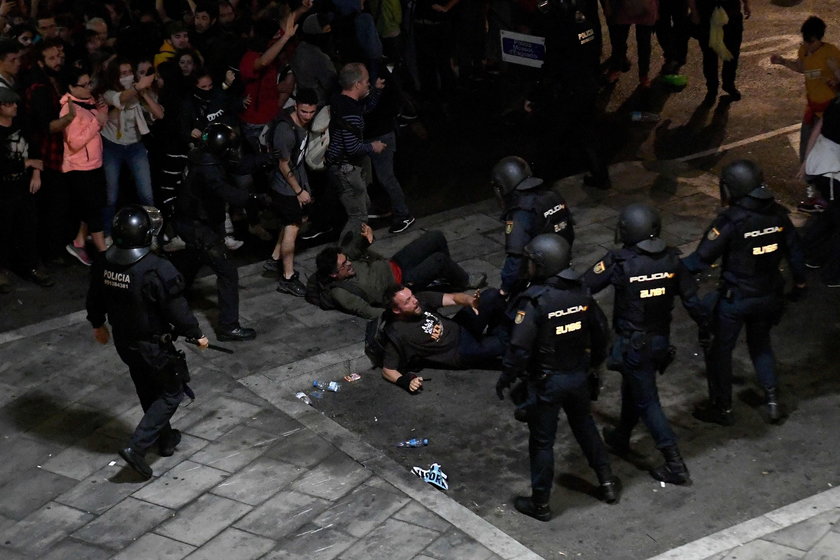 Passengers look as a police officer walks past at Barcelona's airport, during a protest after a verd