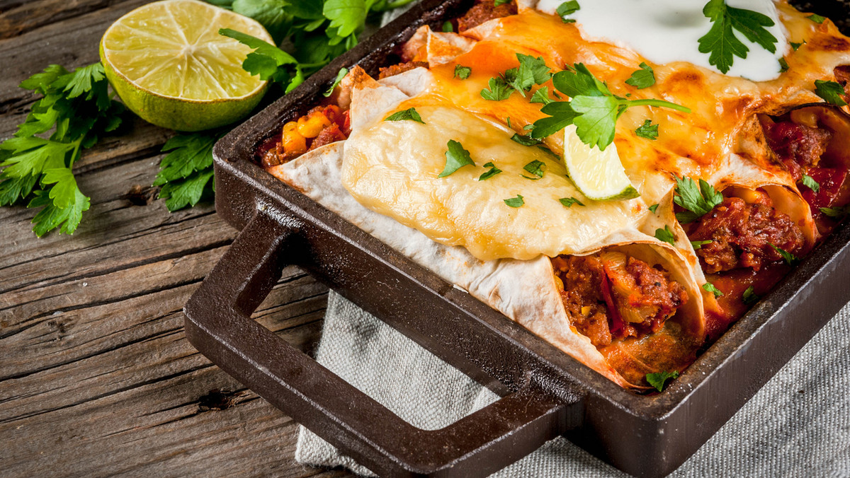 Meksykańska uczta w twoim domu? To możliwe! Zaproś na swój stół enchiladas z kurczakiem i aromatycznym czosnkowym sosem. Chrupiąca tortilla wypełniona mięsno-warzywnym farszem, zapiekana pod pierzynką z sera to danie, które posmakuje każdemu. Jest proste do zrobienia, sycące i naprawdę przepyszne. Przepis na enchiladas jest łatwy, a ich przygotowanie umilają wydobywające się z patelni zapachy. Nie możemy zapomnieć o przyprawach, które są esencją meksykańskiej kuchni oraz czerwonej fasoli i kukurydzy. Enchiladas są pikantne; przepis możemy jednak dowolnie zmieniać, dodając odpowiadającą nam ilość papryczki chilli. Z poniższego przepisu dowiecie się dokładnie jak zrobić enchiladas z kurczakiem, które z pewnością podbiją wasze serca i będą często gościć w waszej kuchni.