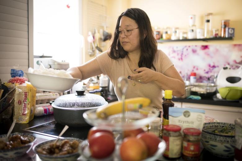 Tiphaine stoi w swojej kuchni i gotuje tradycyjne koreańskie jedzenie 