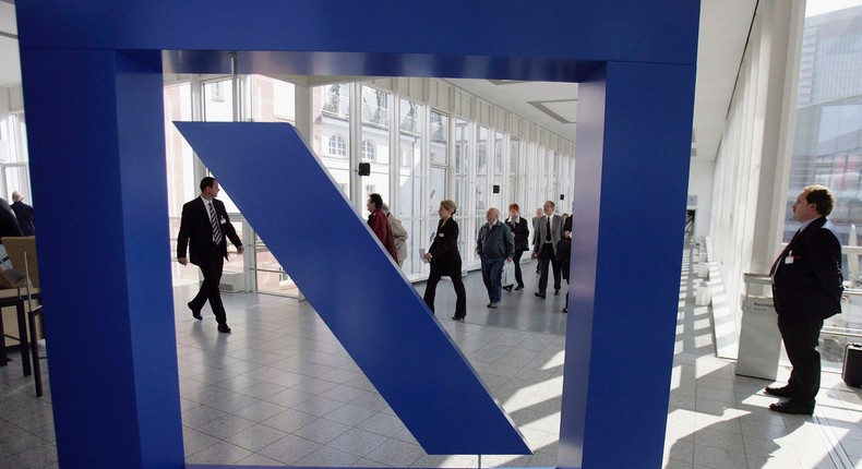 FRANKFURT, GERMANY - MAY 18: Shareholders walk past a huge Deutsche Bank logo during the banks annual shareholders meeting on May 18, 2005 in Frankfurt, Germany. (Photo by Ralph Orlowski/Getty Images)