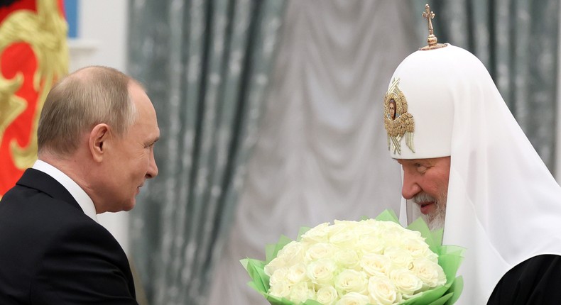 Russian President Vladimir Putin presents flowers during a ceremony to award the Order of St. Andrew the Apostle the First-Called to Patriarch Kirill of Moscow and All Russia in Moscow, Russia November 20, 2021.