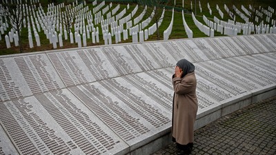 Bida Smajlovic, prays near the Memorial plaque with names of killed in Srebrenica massacre before wa