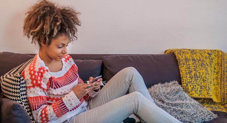 woman texting on couch