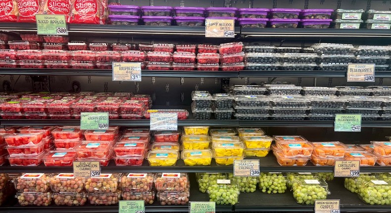 Sliced fruit, grapes, and strawberries filled in a different section of the refrigerator.