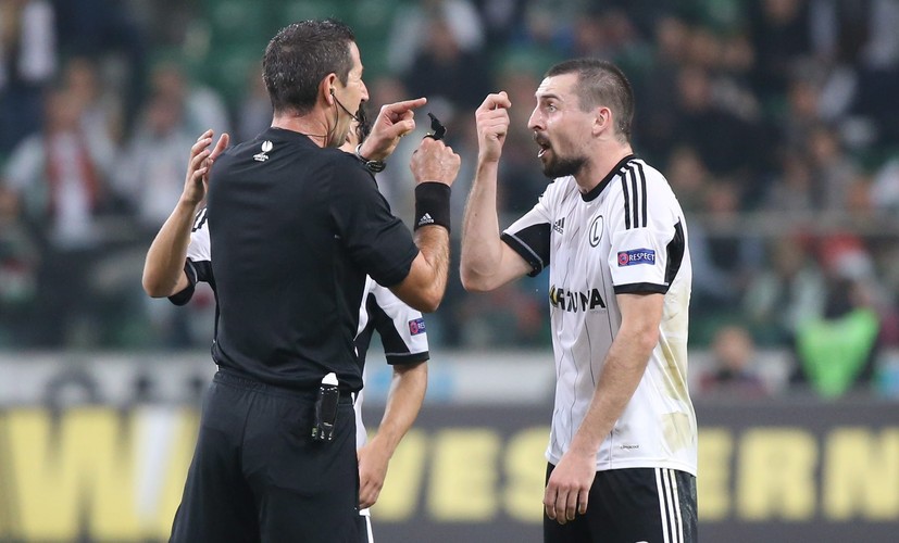 Zawodnik stołecznej Legii Michał Kucharczyk (P) upominany przez sędziego głównego Eitana Shemeulevitcha (L) podczas meczu grupy L piłkarskiej Ligi Europejskiej z Metalistem Charków, rozgrywanego na Pepsi Arenie w Warszawie