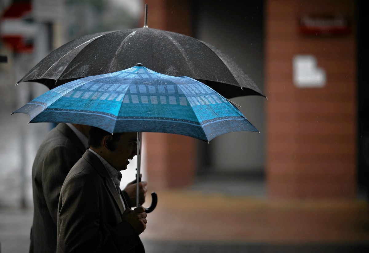 Przechodnie pod parasolami