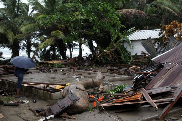 A local stands next to a damaged house as Hurricane Irma moves off the northern coast of the Dominic