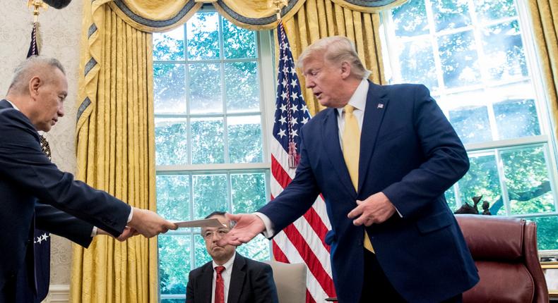 President Donald Trump receives a letter presented to him by Chinese Vice Premier Liu He, left, in the Oval Office of the White House in Washington, Friday, Oct. 11, 2019. (AP Photo/Andrew Harnik)