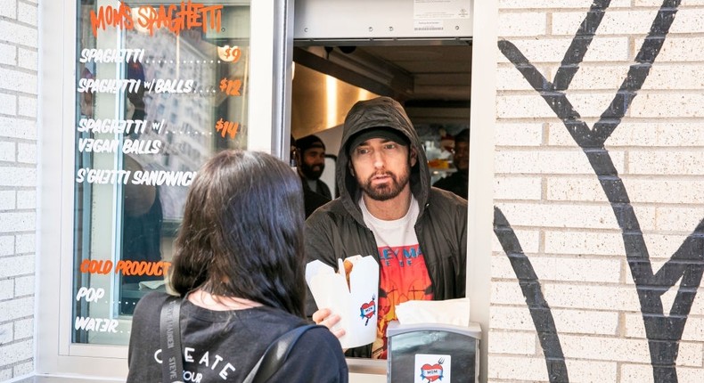 DETROIT, MICHIGAN - SEPTEMBER 29: Eminem serves Mom's Spaghetti to a fan on the opening night of his restaurant Mom's Spaghetti on September 29, 2021 in Detroit, Michigan. (Photo by Scott Legato/Getty Images)