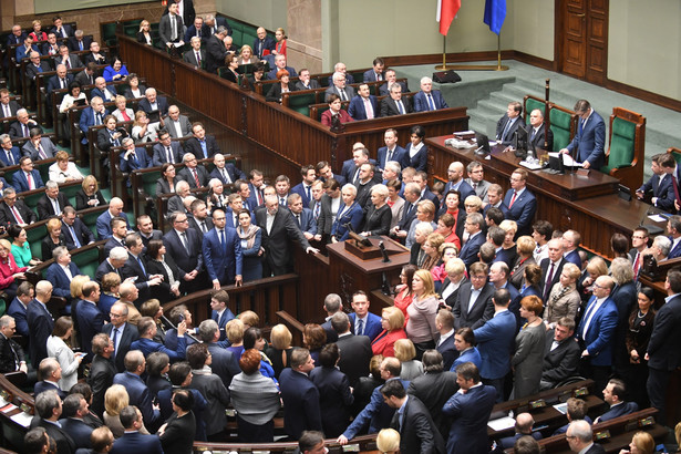 Część posłów opuściła salę plenarną. Wokół mównicy sejmowej pozostaje grupa posłów PO.