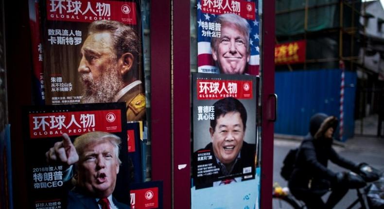 Advertisements for a magazine showing various cover stories, including ones featuring US President-elect Donald Trump, at a newsstand in Shanghai