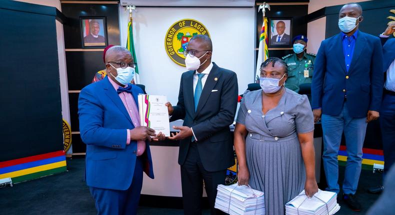L-R: Chairman, Special Visitation Panel on the appointment of the 9th Vice Chancellor for Lagos State University (LASU), Prof. Bamitale Omole, presenting the report of the panel to the Lagos State Governor, Mr Babajide Sanwo-Olu. With them: Secretary of the Visitation panel, Mrs Funmilola Olajide, during the presentation of the report by the panel at Lagos House, Ikeja, on Monday. [Twitter/@jidesanwoolu]