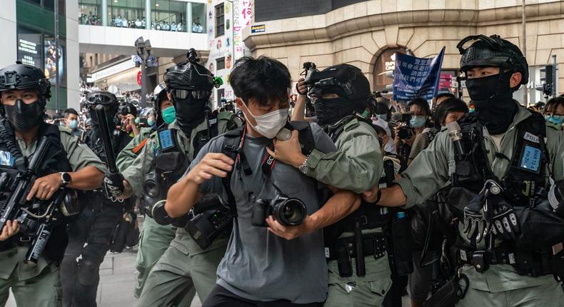 A pedestrian is detained by riot police in Hong Kong on May 27, 2020.