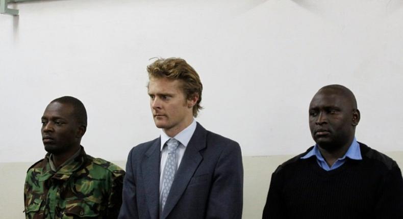 British national Jack Alexander Wolf Marrian (C), flanked by police officers, appears in court in Nairobi on August 8, 2016, where he faces charges of trafficking 100 kilos of cocaine from Brazil to the port of Mombasa