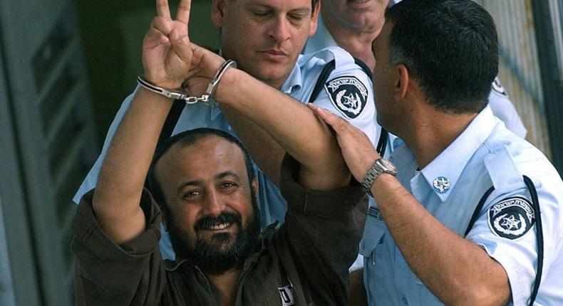 The leader of hundreds of Palestinian hunger strikers in Israeli jails, Marwan Barghouti, who has received his first Red Cross visit since the strike began, flashes the victory sign after a court hearing in 2003