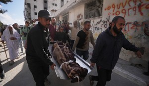 Palestinci nose telo osobe poginule u izraelskim vazdušnim napadima u petak, usmerenim na Iza al Dina al Hadada, vođu Hamasa