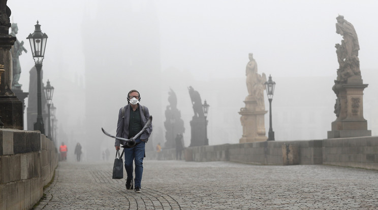 Védőmaszkos férfi megy a prágai Károly hídon 2021. február 24-én. Csehországban rekordmagasra nőtt a kórházban kezelt súlyos koronavírus-betegek száma, ezért a kormány úgy döntött, hogy szigorít a vírus miatt bevezetett korlátozásokon./ Fotó: MTI/AP/Petr David Josek