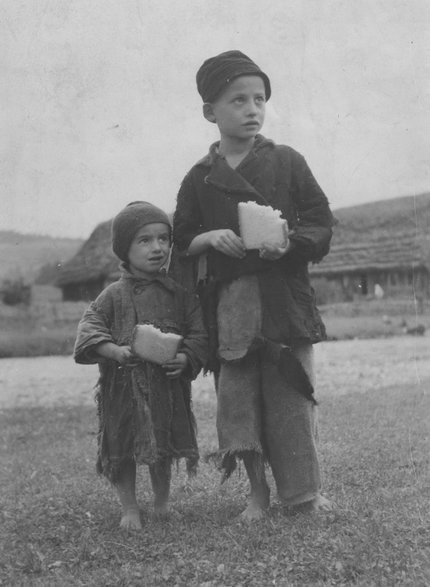 Ubodzy chłopcy posilający się kromką chleba. (fot. domena publiczna)
