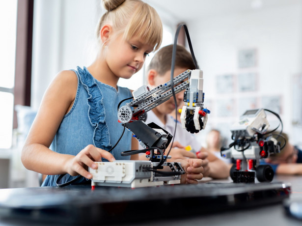 Dziewczynka konstruuje robota. Nauka